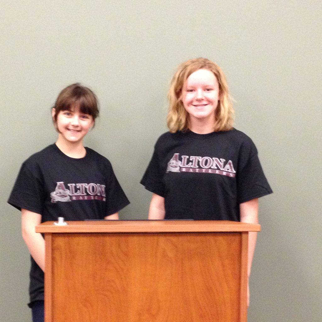 Two girls standing behind a podium