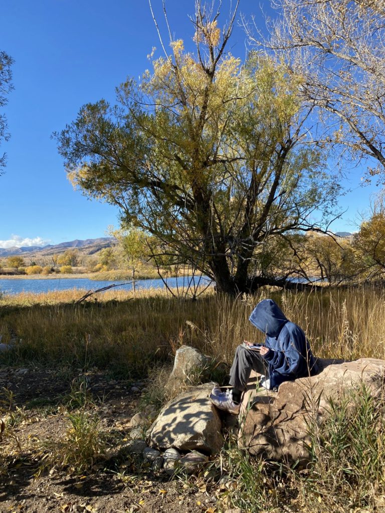 Student writing in nature