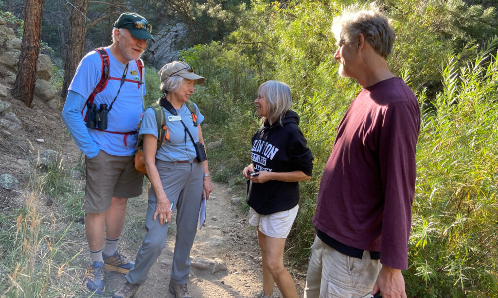 Two volunteers interacting with two trail users.