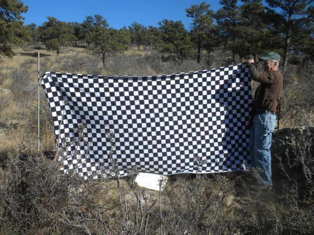 Volunteers holding up a cover blanket during shrub monitoring.