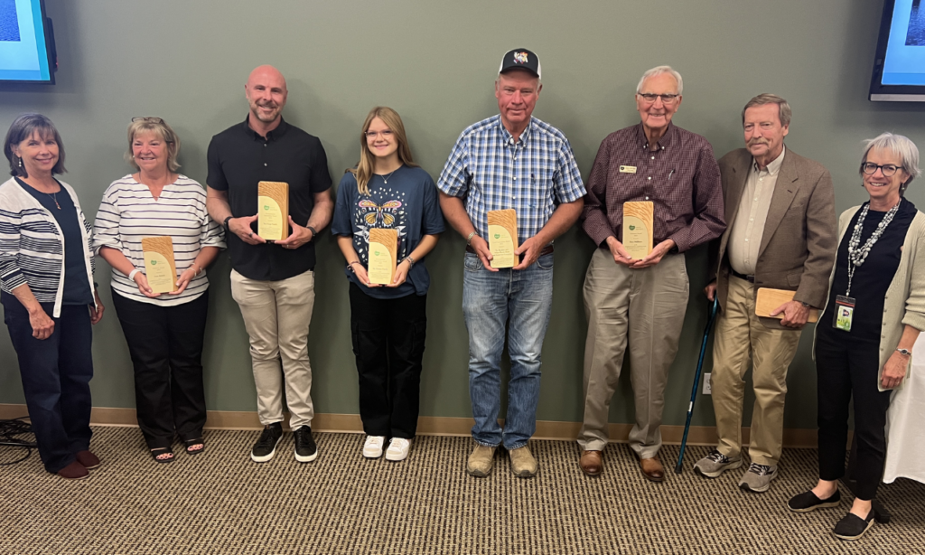 Award recipients holding their plaques. From left to right: Parks & Open Space Director Therese Glowacki, Anne Janicki, Brian Hepp, Emma Rooney, President of The Boulder and White Rock Ditch and Reservoir Company Jules Van Thuyne, Dave Millhiser, Keith Owen, and Commissioner Claire Levy