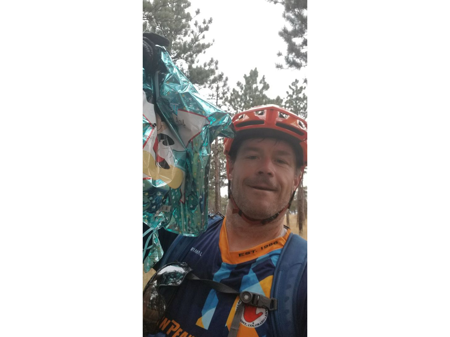 Mountain biker holding up a bag of trash